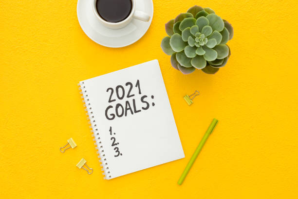 istock New year goals list. Christmas decorations and notebook on yellow 1287182234
