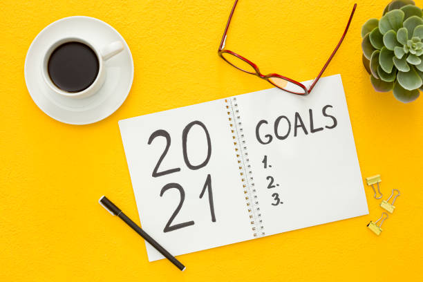 istock New year goals list. Christmas decorations and notebook on yellow 1287182242