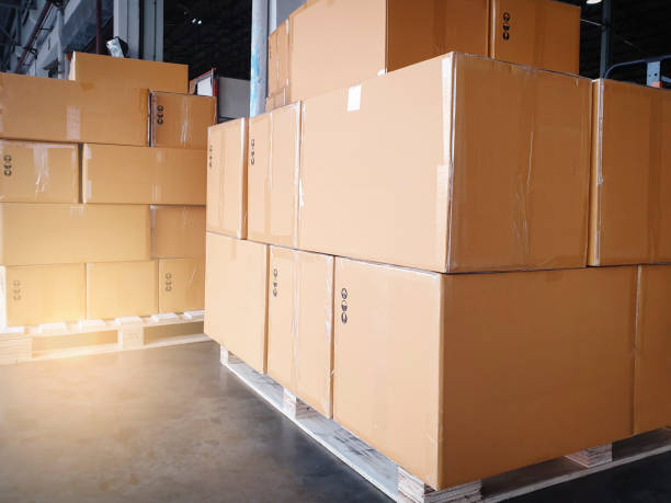 istock Cargo shipment boxes. Stack of cardboard boxes on pallet rack at the warehouse storage. Manufacturing and warehousing. 1287182381