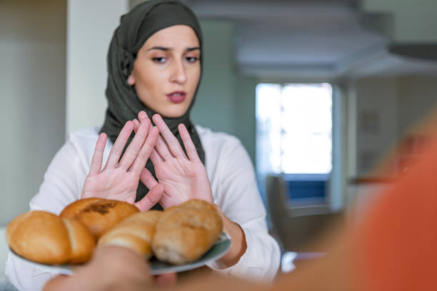 mulher muçulmana recusando um alimento não saudável - gluten allergy - fotografias e filmes do acervo