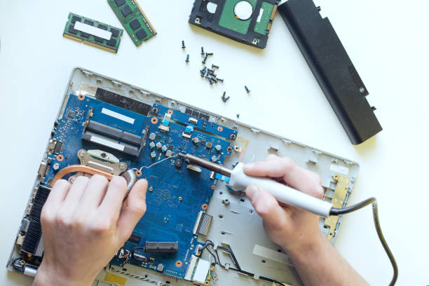 istock A man repairs a laptop, disassembles a laptop on a white background, solders the laptop motherboard 1287189158