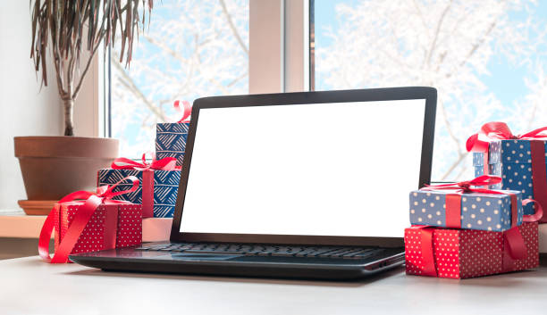 istock Blank display screen laptop computer on white table near window. Mock up copy space. Winter sales, online shopping. 1287189353