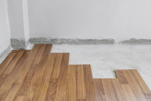 istock Wooden flooring installation and renovation, with base cement floor. Under construction 1287190268