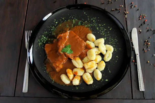 Photo of Pasticada with gnocchi, beef stew in a sauce. Croatian cuisine
