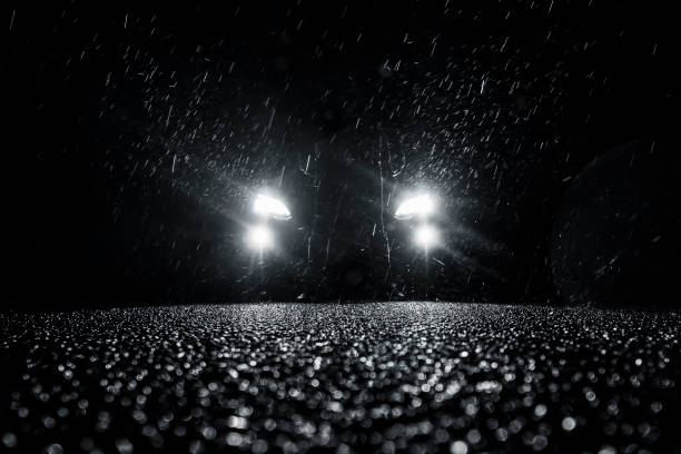 glowing car headlights at night in the rain