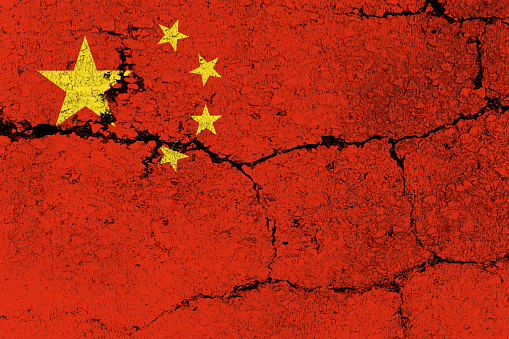 Chinese Flag on cracked wall background.