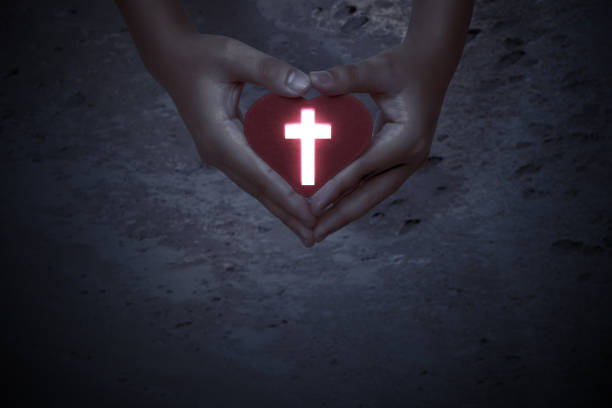 istock Human hands showing red heart with Christian cross 1287194610