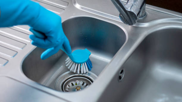 用刷子和藍色手套清潔廚房灰色金屬水槽。 - 洗碗刷 個照片及圖片檔