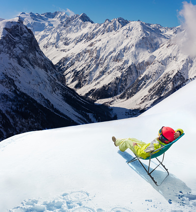 Young woman rest in cafe the deck chair on top of the mountain and Alpine peaks
