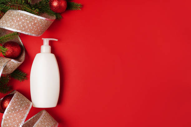 istock White bottle shampoo or gel and Christmas decorations on a bright red background. Mockup, Top view, new Year flatlay. 1287200316