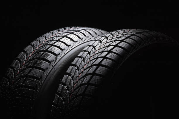 istock Winter Car tire on black background 1287201170