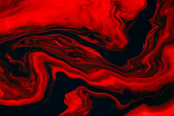 Photo of Fluid art texture. Backdrop with abstract swirling paint effect. Liquid acrylic picture that flows and splashes. Mixed paints for background or poster. Red, black and orange overflowing colors.