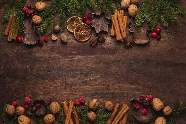 istock Bakery Christmas or New Year holiday  background with cinnamon, cranberries, nuts, anise, brown sugar, dried oranges, nutmeg. Rustic wooden brown background 1287201425
