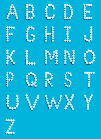 Colorful alphabet made of white round pills for design. Pharmaceutical sign symbol. Alphabet font medicine.