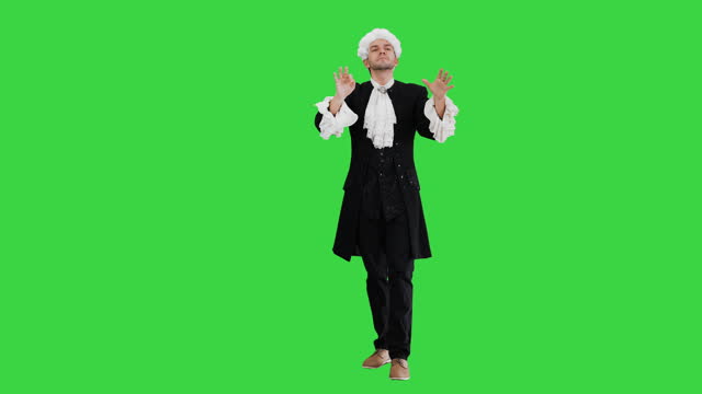 Man dressed like Mozart conducting expressively while looking at camera on a Green Screen, Chroma Key