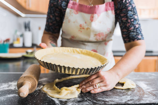 istock Young housewife preparing apple pie at home wearing apron. 1287203316