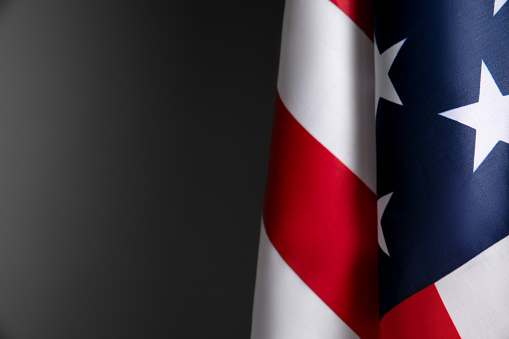 Horizontal frame arrangement. Closeup of American flag on dark grey background. Flyer. Web banner template for USA Independence day or Memorial Day or 4th of July. Copyspace for ad, offer, design.