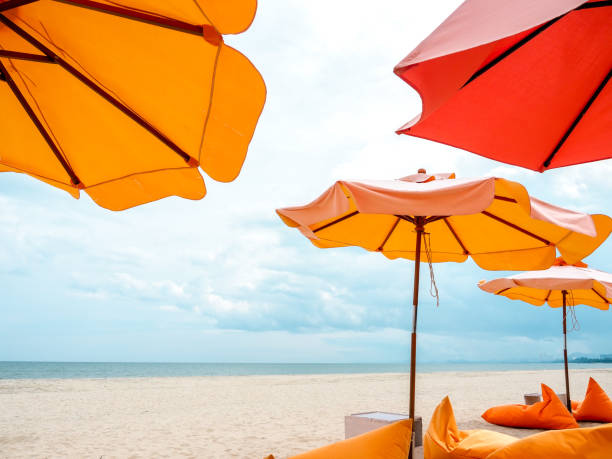 istock Orange beach umbrellas and bean bag chairs on the beach. 1287206651