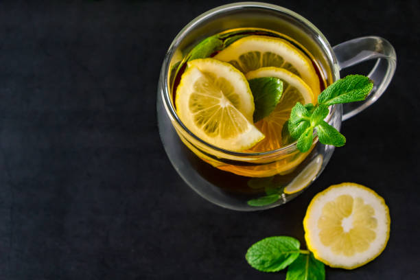 istock Herbal tea with lemon and mint on dark background. Delicious drink for relaxation and refreshment 1287208093