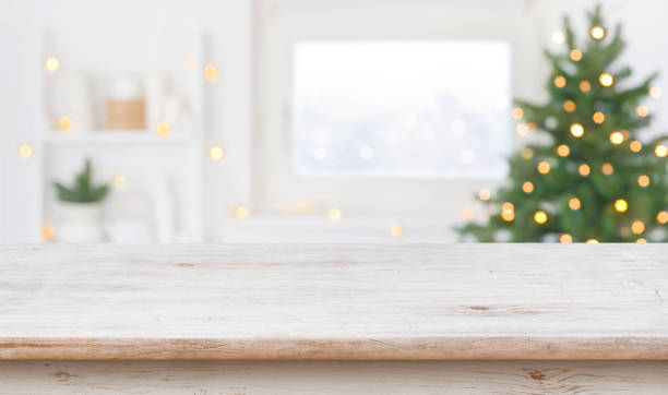 espacio de mesa frente al alféizar de la ventana desenfocado con árbol de navidad - xmas fotografías e imágenes de stock