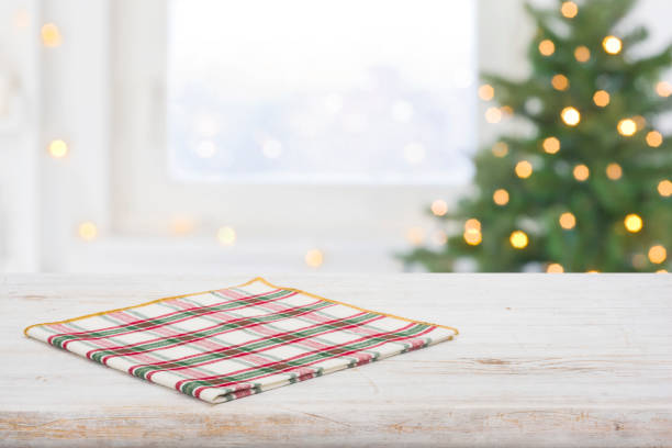 istock Checkered napkin on table and frosty window with Christmas tree 1287210364