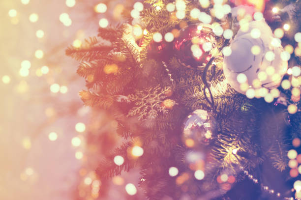 istock Christmas tree branch with christmas balls and lights, soft focus. Blurred lights background for your ad, poster, banner 1287212767