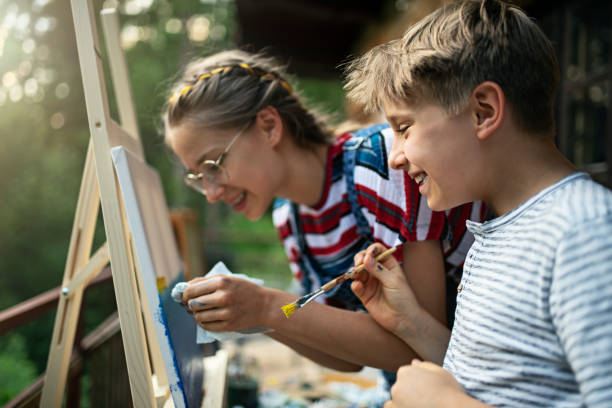 istock Brother and sister painting on easel 1287213519