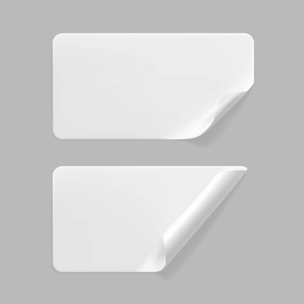 istock White glued rectangle stickers with curled corners mock up set. Blank white adhesive paper or plastic sticker label with wrinkled and creased effect. Template label tags close up. 3d realistic vector 1287214506