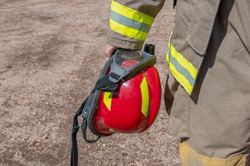 firefighter holding red safety helmet. Horizontal photo