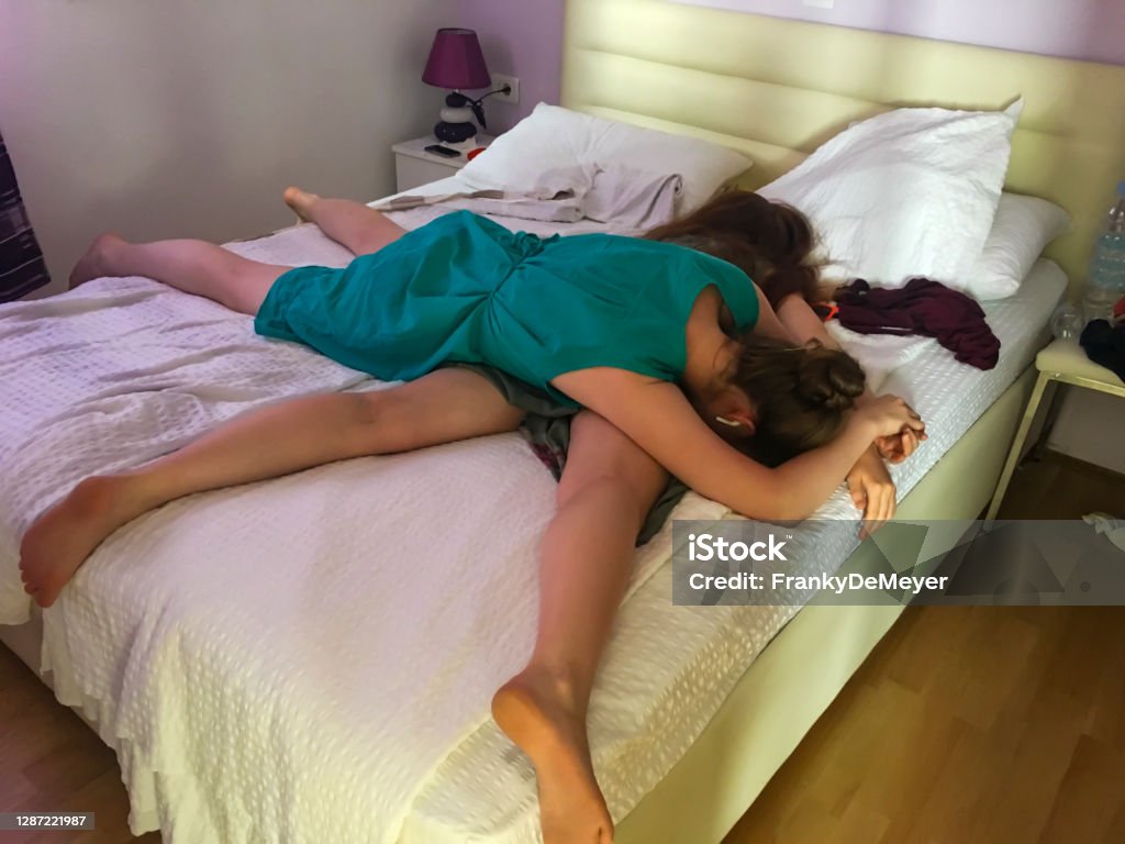 Exhausted teens after a full day at the beach Two sisters, aged 16 and 17 fallen exhausted in bed after a busy day at the beach. Relaxation Stock Photo