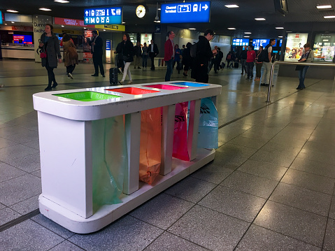 16 May 2019, Gare du Midi, Brussels, Belgium: a colorful combo of 4 recycle bins in the Brussels south railway station (Gare du Midi). Travellers are encouraged to use separate trash cans depending on the type of waste: paper, plastic/metal, glass and the rest.