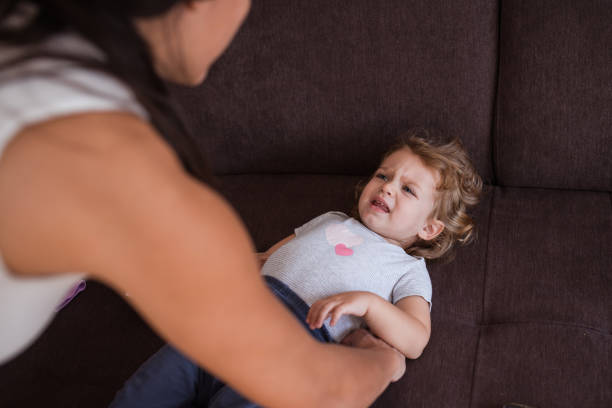 istock Sad child about to cry because mother is dressing it up 1287223765