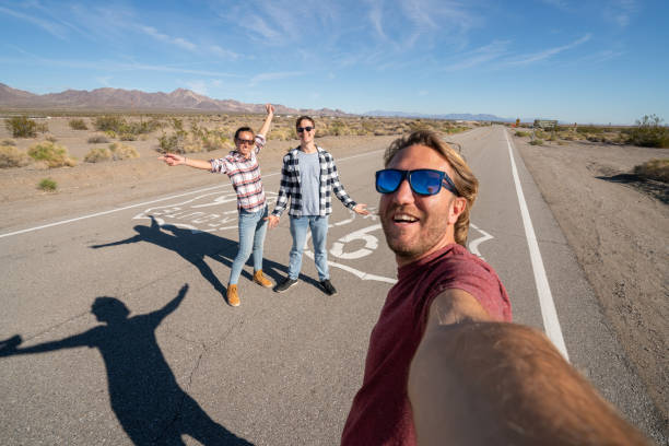 des amis prennent un selfie sur la route 66 - road trip sign journey route 66 photos et images de collection