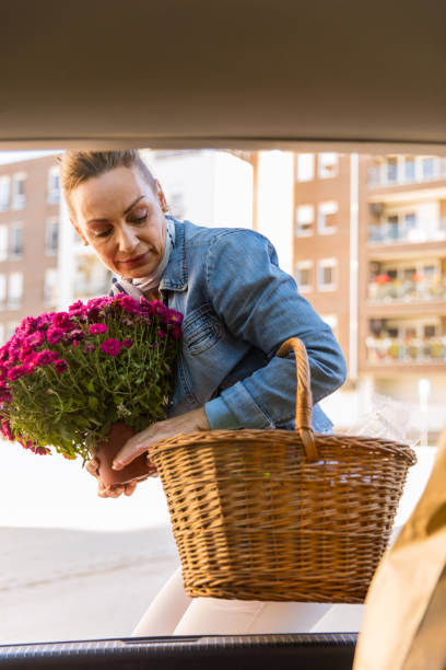 istock Putting her basket and flowers in a car trunk 1287229424