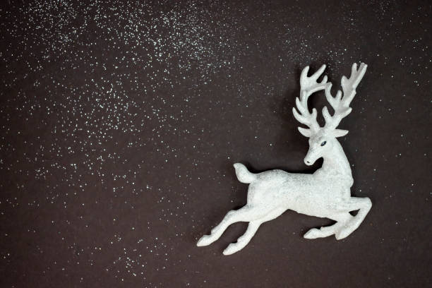 istock Christmas background. Deer figurine on dark background with sparkles. Flat lay, place for text. 1287230492
