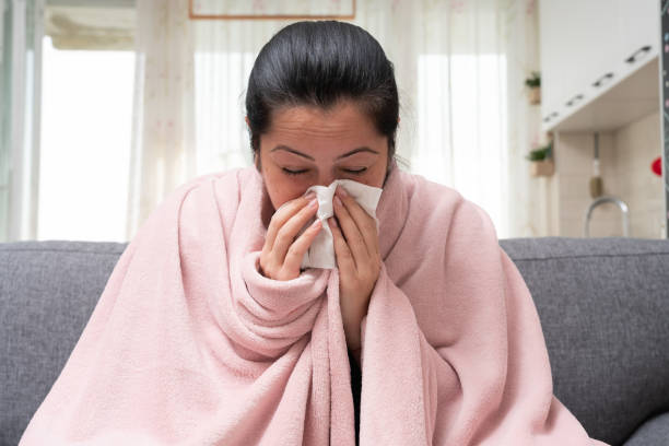 istock Sick adult female model blowing nose as sinusitis concept 1287230521