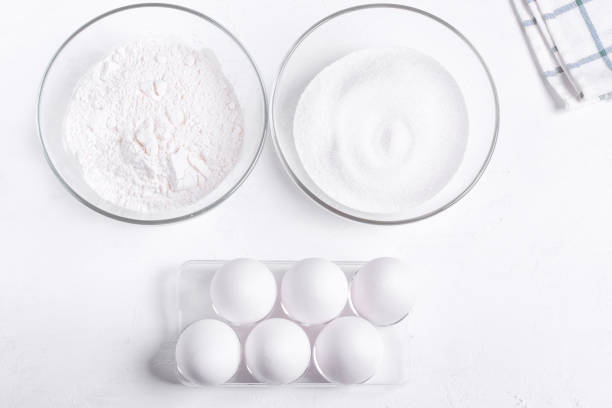 istock Step by step recipe of sponge cake. Step 1. Ingredients to make sponge cake. Eggs, sugar and flour on the white table 1287231722