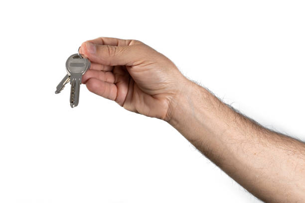 istock hand holding keychain with two keys on white background 1287232339