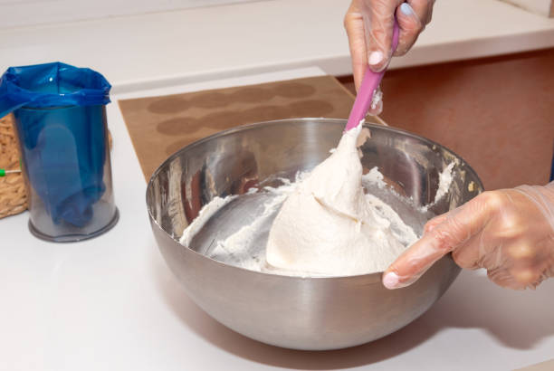 istock Mixing the dough with a spatula in a metal bowl. 1287232514