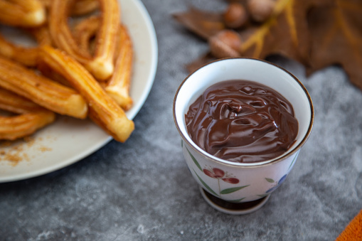 view of a small bowl with hot chocolate and some fried sweets