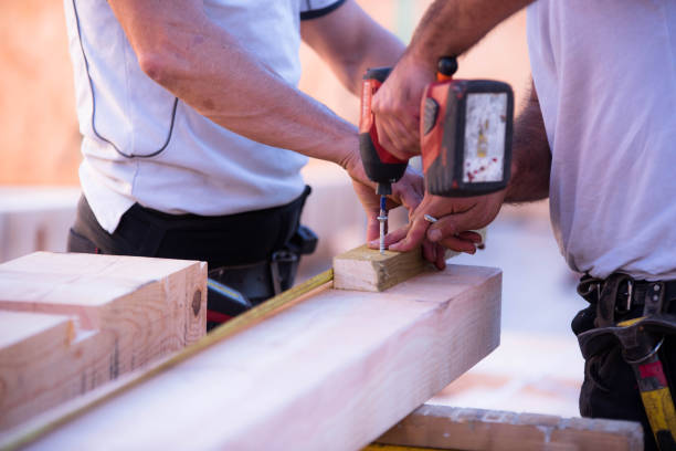 istock worker screwing on a construction site to build a wooden house 1287233912