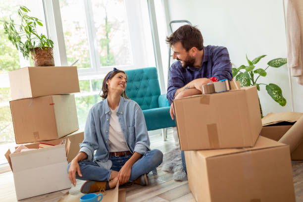 istock Couple paking things in cardboard boxes while moving house 1287234122