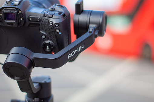 London, UK - February 14, 2020: Ronin stabilizer and camera up close with blurry street as background. Modern Camera capturing blurry cityscape. Photography and video equipment