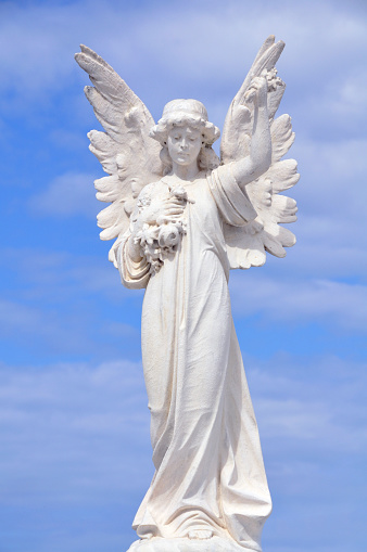 White angel grave yard statue with blue sky