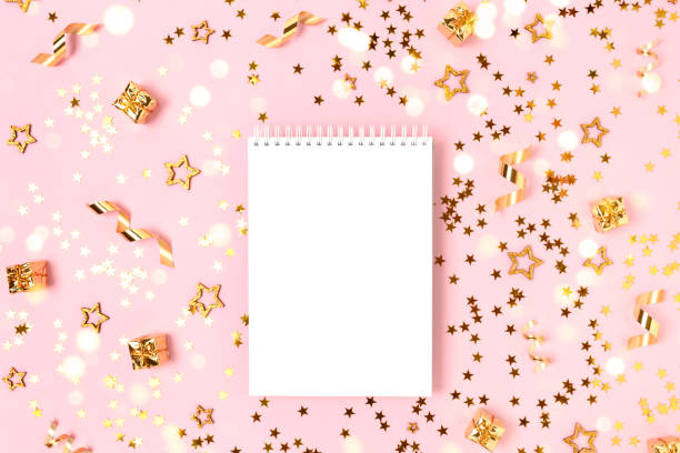 istock Notebook template on a pink background with gold confetti. 1287239091