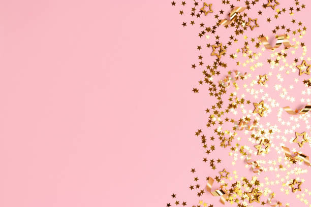 istock Gold stars confetti on a pink pastel background. 1287239678