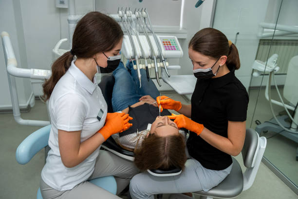 female dentist and young assistant doing repairing patient tooth in dental ambulant - ambulant patient imagens e fotografias de stock