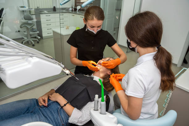 female dentist and young assistant doing repairing patient tooth in dental ambulant - ambulant patient imagens e fotografias de stock