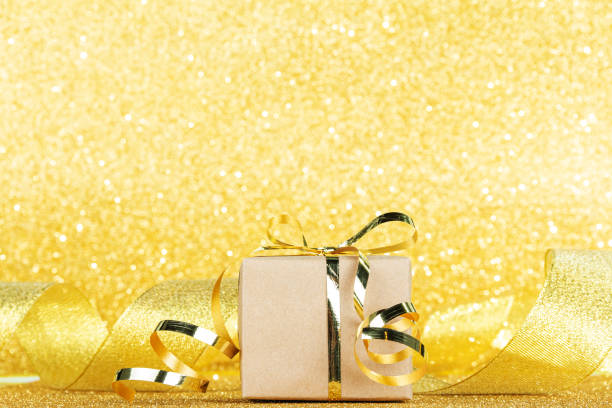 istock Gift close-up on gold ribbon background and sparkling background 1287241241
