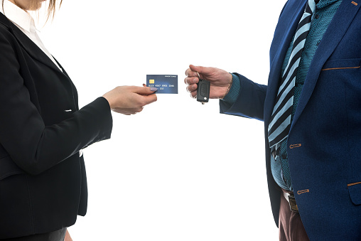 buying or renting a car. businessmen isolated on white holding credit card and keys.